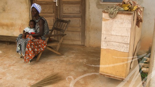 Fotografía social. Costa de Marfil. Mujer con niño en la puerta de su casa