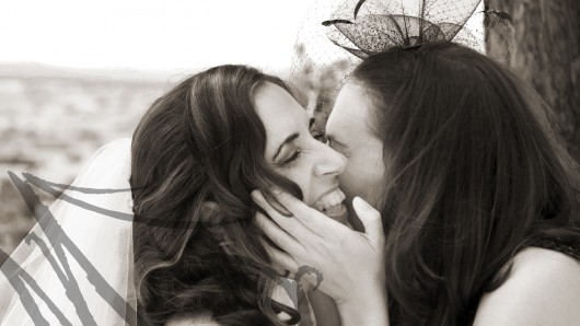Fotografía de bodas. Retrato del momento del beso de dos hermanas el día de la boda