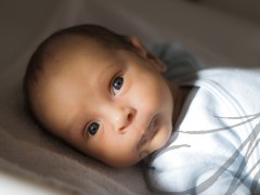 Fotografía en plano medio de un bebé de mes y medio tumbado