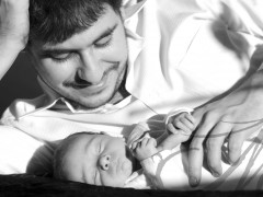 Fotografía en blanco y negro de un papá con su bebé agarradito de su mano