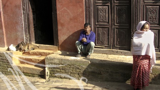 Fotografía de viajes, Nepal. En la puerta de una casa, en la calle, un hombre, una mujer y dos cabritas componen la escena