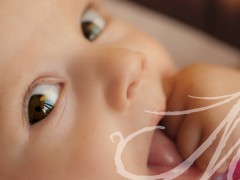 Fotografía detalle del ojo de un bebé de tres meses, chupándose la mano