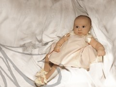 Fotografía de un bebé de cuatro meses, vestido de bautizo.