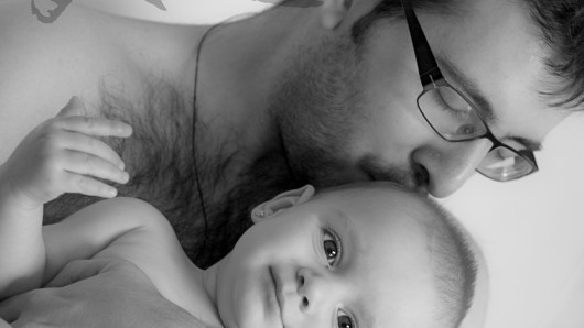 Fotografía en blanco y negro de un bebé con su padre en brazos