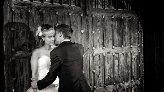 Fotos de boda, Lourdes y David. Fotógrafa: Lourdes Martín Montilla. Martinmontilla photography. El novio besa a su mujer contra una puerta de madera